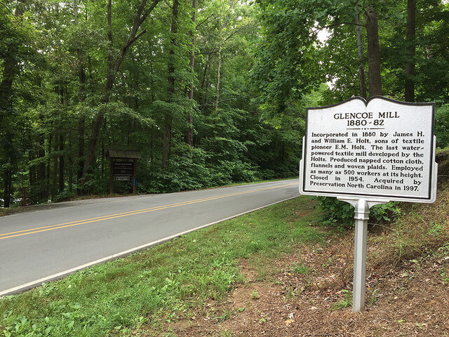 photo on the road of the Glencoe Mill historical marker with the Glencoe Mill Paddle Access entrance on the left
